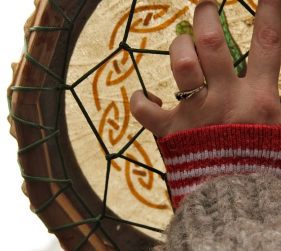 Close up of hand holding hide hand drum