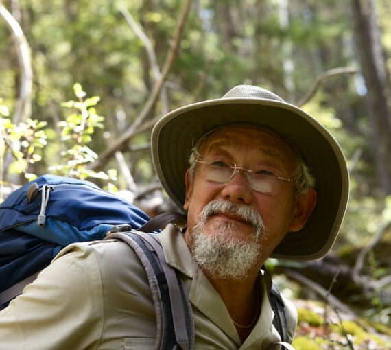 Male hiker walks through forest